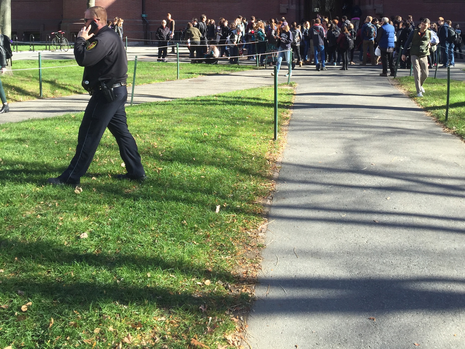 Students flood out of Sever Hall Monday after Harvard University received an unconfirmed bomb threat. Harvard University Police Department officers worked with local and federal authorities to investigate the scene.