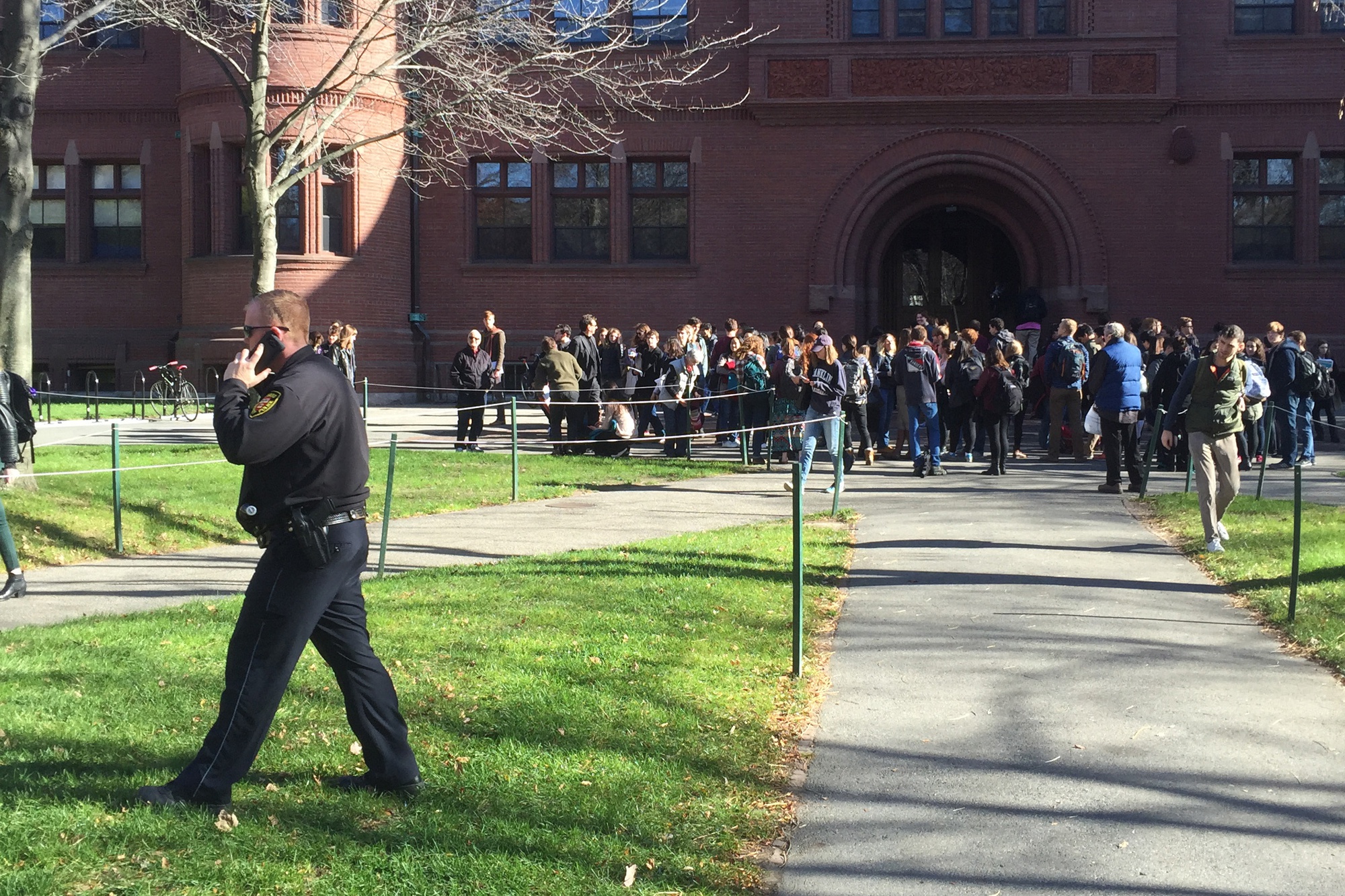 Students flood out of Sever Hall Monday after Harvard University received an unconfirmed bomb threat. Harvard University Police Department officers worked with local and federal authorities to investigate the scene.