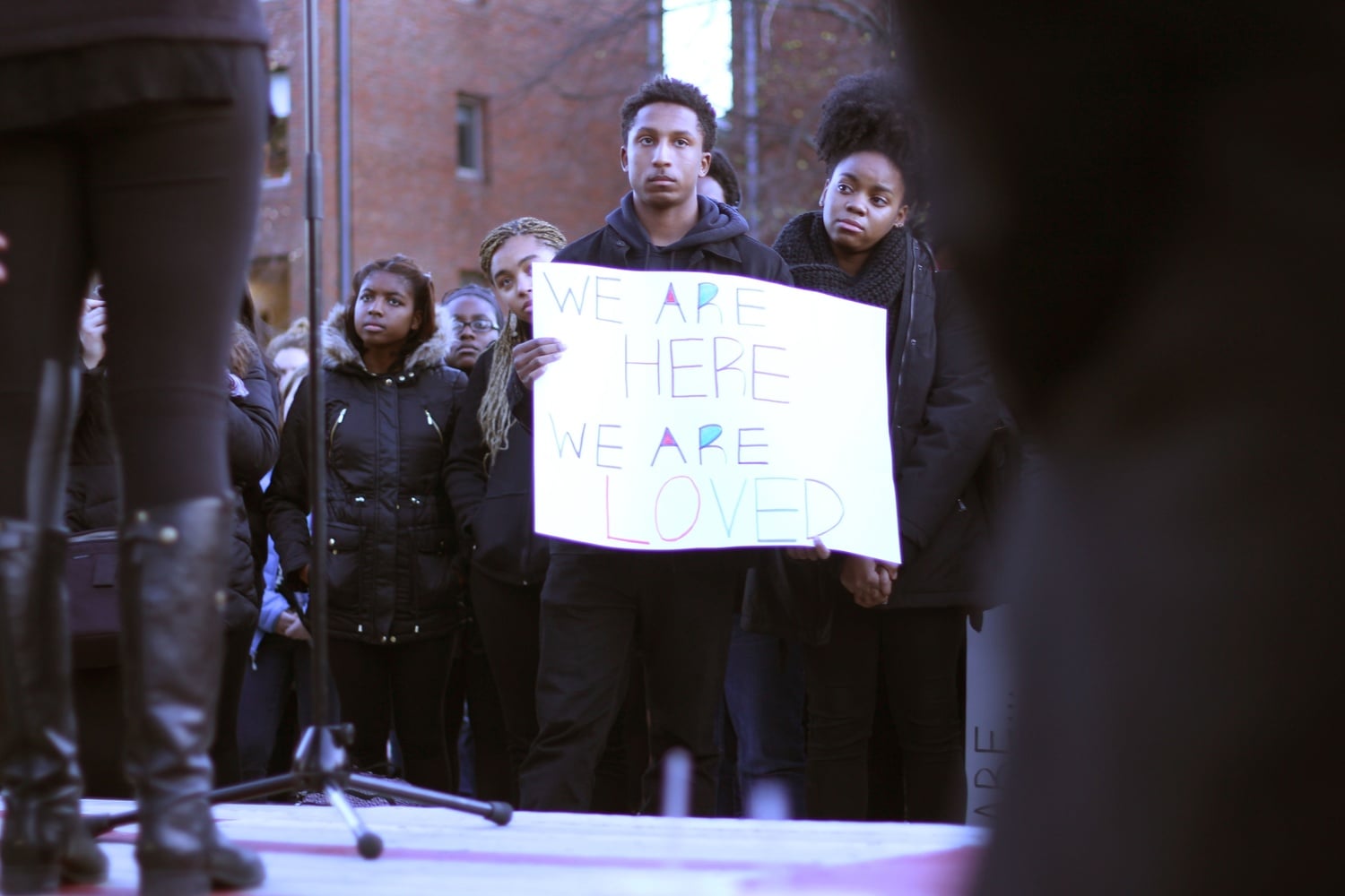 Hasani A. Hayden '19 holds up a banner during a rally at the Science Center in November.  Students rallied and marched to Porter Square in support of black student activists at peer schools such as Yale and the University of Missouri.
