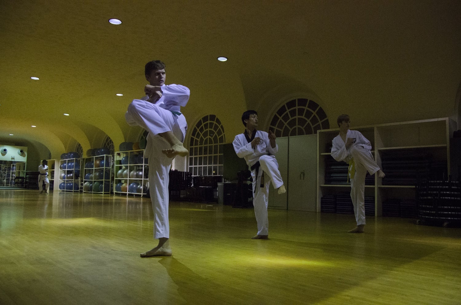 Inkwon Jang, center, Taekwondo master and instructor, guides graduate student Dmitry Vinichenko, left, and Thomas R. Lively ’18, right, through a series of exercises at the Malkin Athletic Center on Monday.