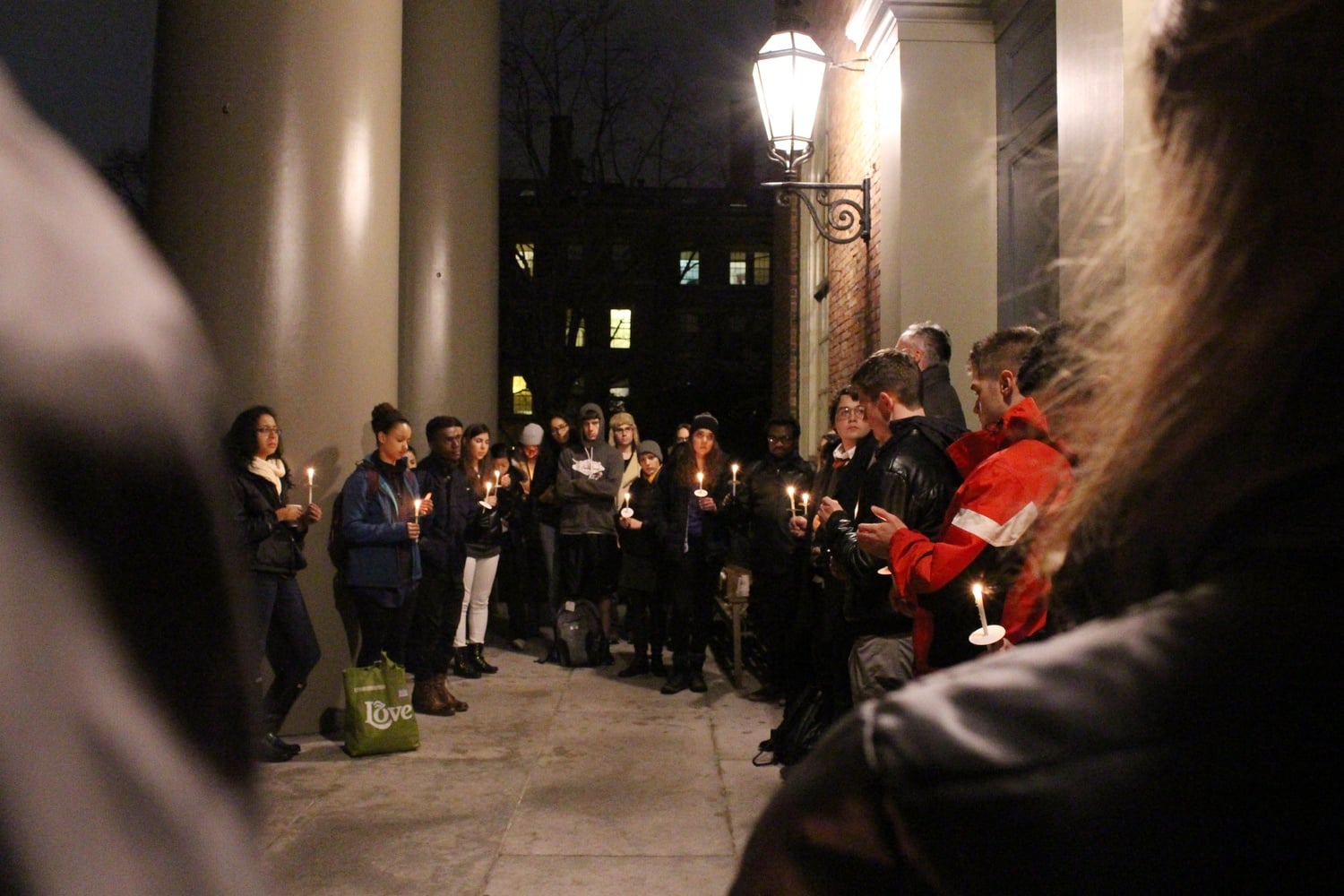Students stand during a moment of silence at the end of the AIDS Day vigil on Tuesday night.
