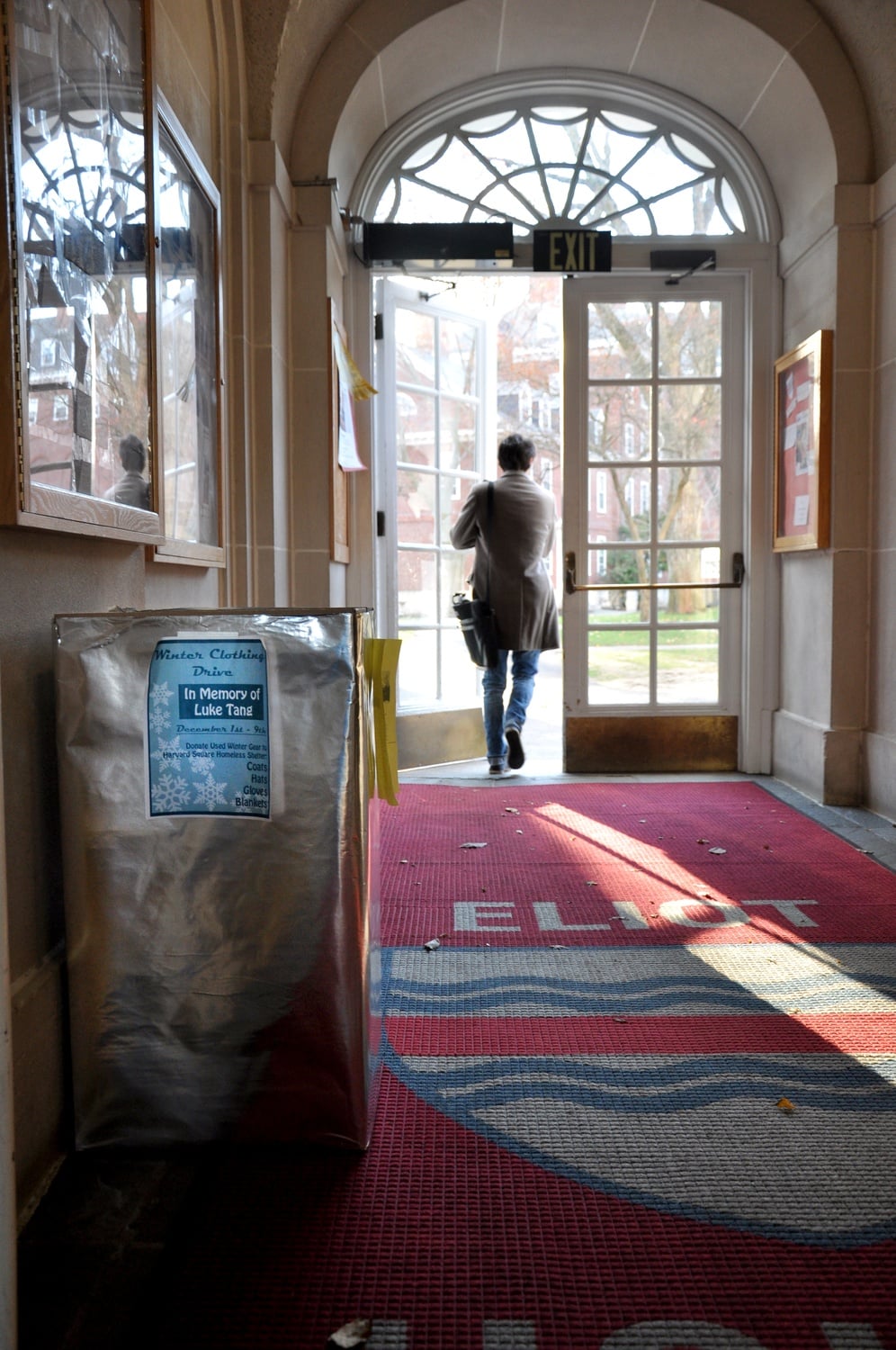 A winter clothing drive collection box sits outside of the Eliot dining hall marked with a flyer that reads “In Memory of Luke Tang.” This week the Phillips Brooks House Association and Harvard Square Homeless Shelter together launched the drive, asking students to donate winter clothing to the homeless.