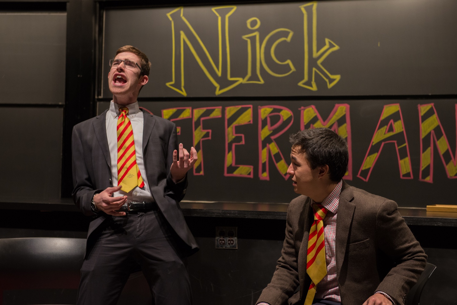 Grant A. Hoechst '18 pantomimes playing a guitar in an improv sketch with Adam S. Wong '17.