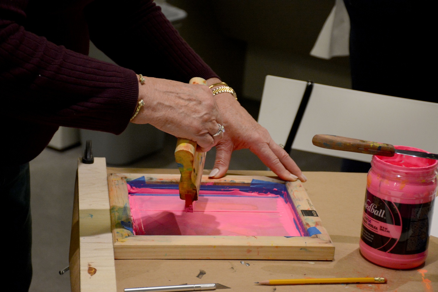 An attendee works on her silkscreening print at a Harvard Art Museums Materials Lab workshop. Visitors pressed ink through screens to create stenciled designs.