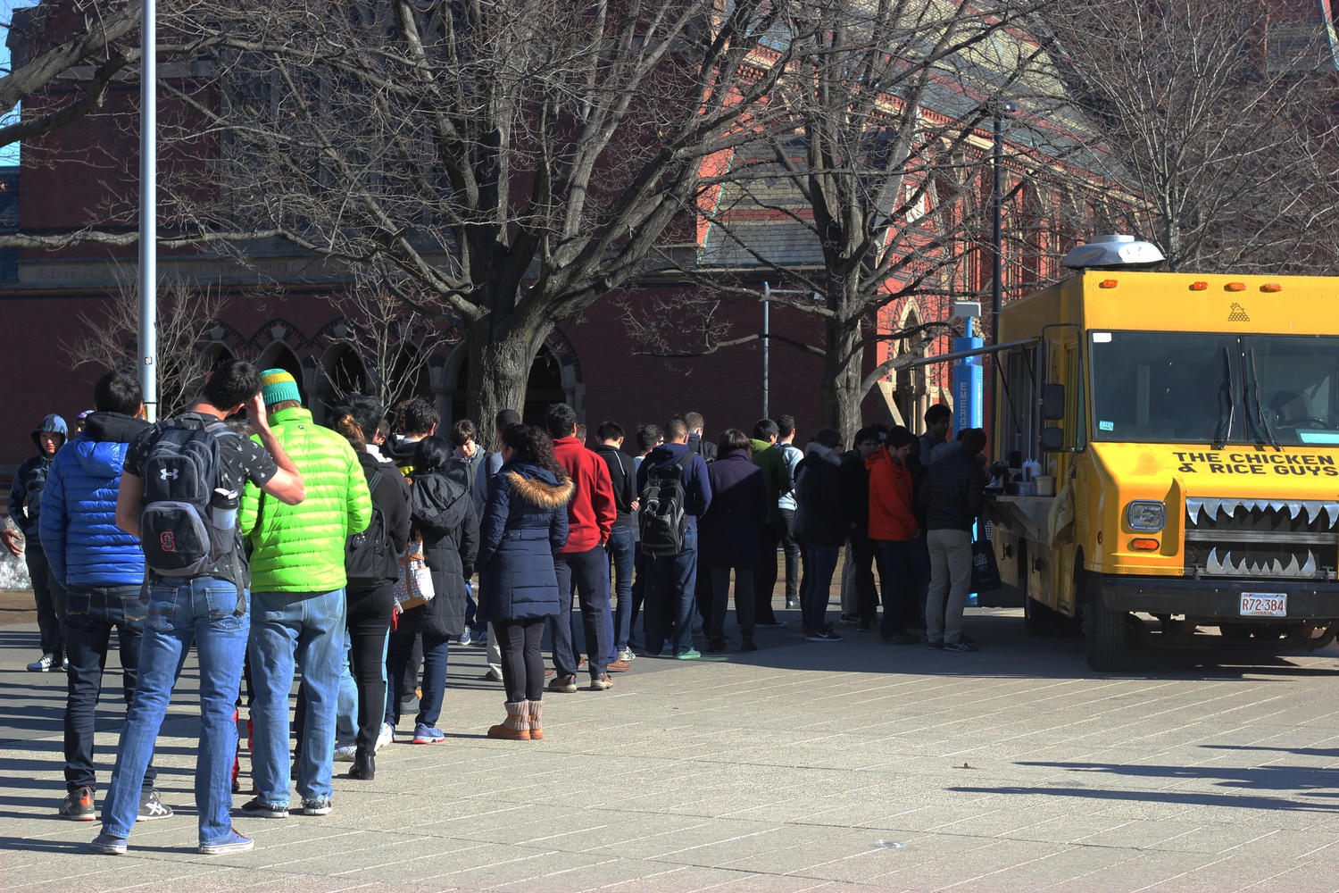 A line forms outside of the Chicken and Rice Guys food truck at the Science Center plaza. Northeastern students recently triumphed over Harvard in a Facebook competition that offered free snack size meals for a day to the winning study body. 