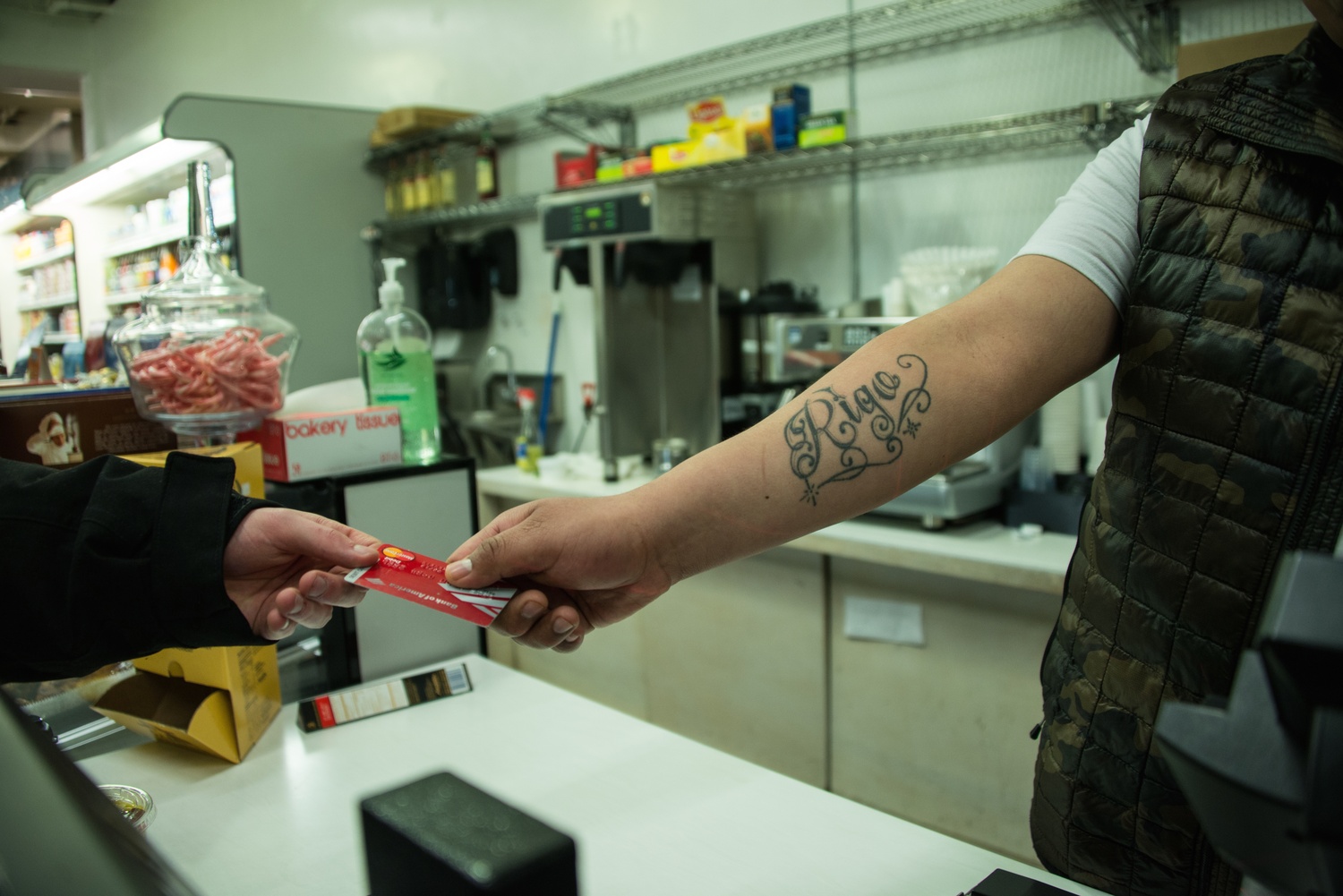 Rigo, the night shift worker at the Market in the Square, hands a credit card back to a customer.  Fifteen Minutes Magazine wrote about Rigo in a February profile.