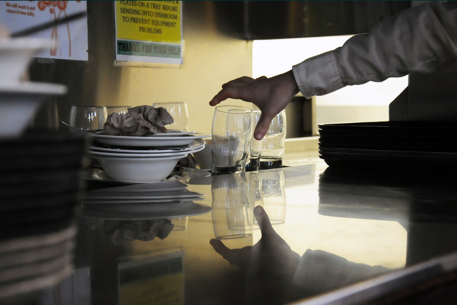 A student places a glass onto the dish return in Adams's dining hall.  After a broken pipe interfered with the dining hall’s disher washers, Adams residents were left using plastic cutlery for several days this week.  