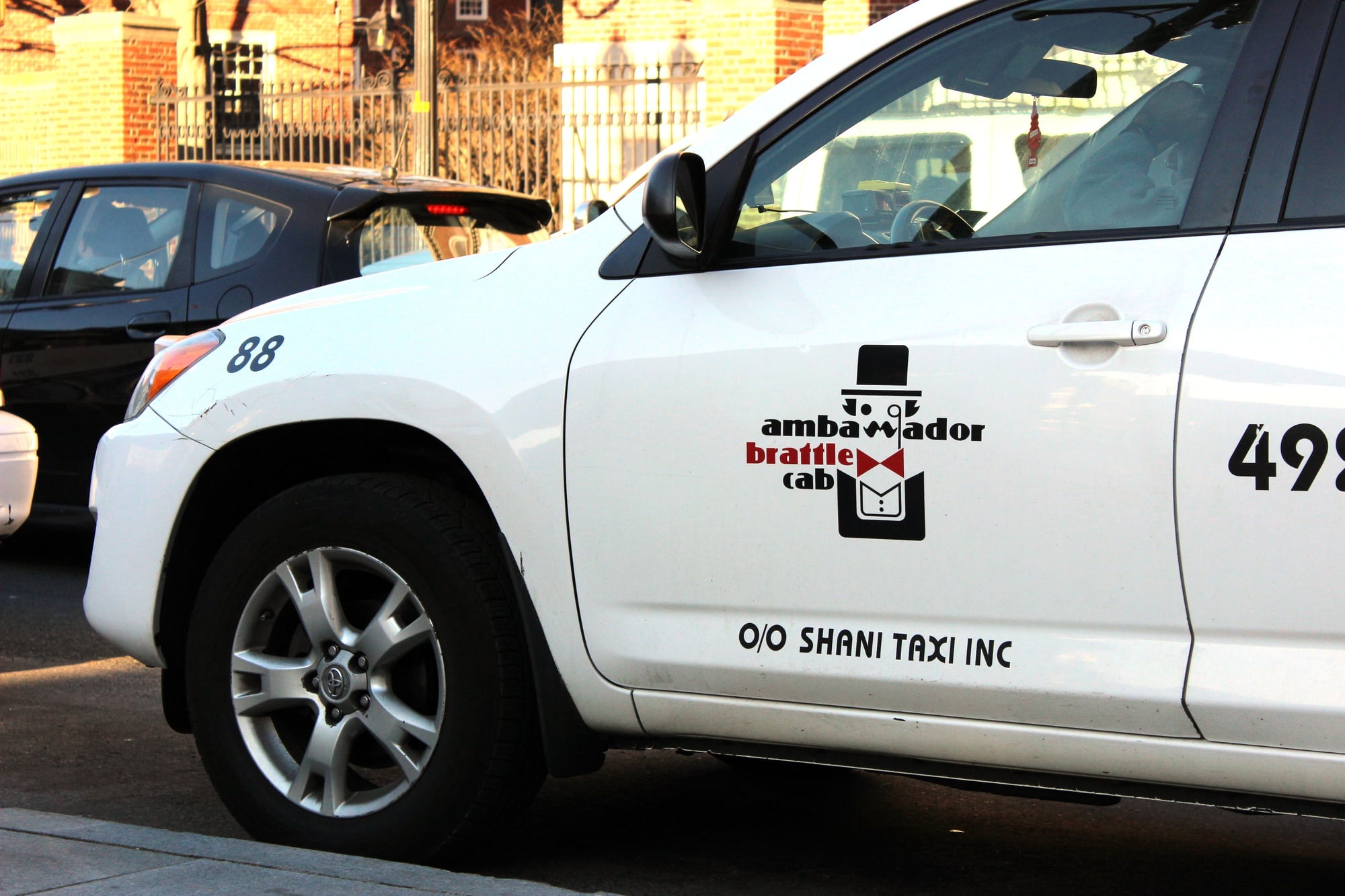 An Ambassador Brattle Cab taxi stands idle in Harvard Square Thursday afternoon. Ambassador Brattle Cab is one of the multiple taxi service companies adopting mobile technology to increase ridership. 