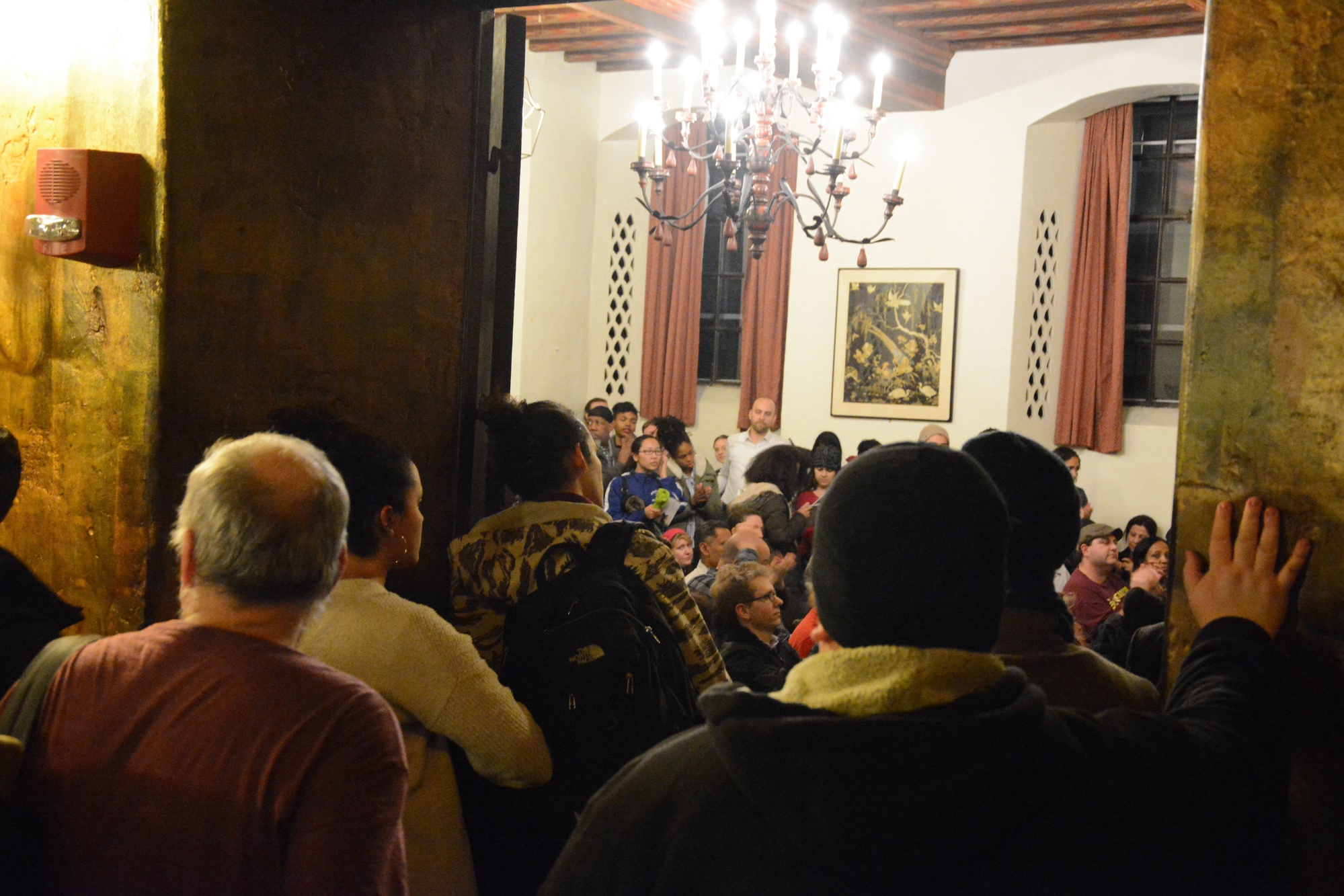 Students and workers line the edges of Adams’ Junior Common Room to protest in support of HUDS workers health care benefits. There was a high turnout at the event, which featured leaders from several Harvard college and graduate student groups.