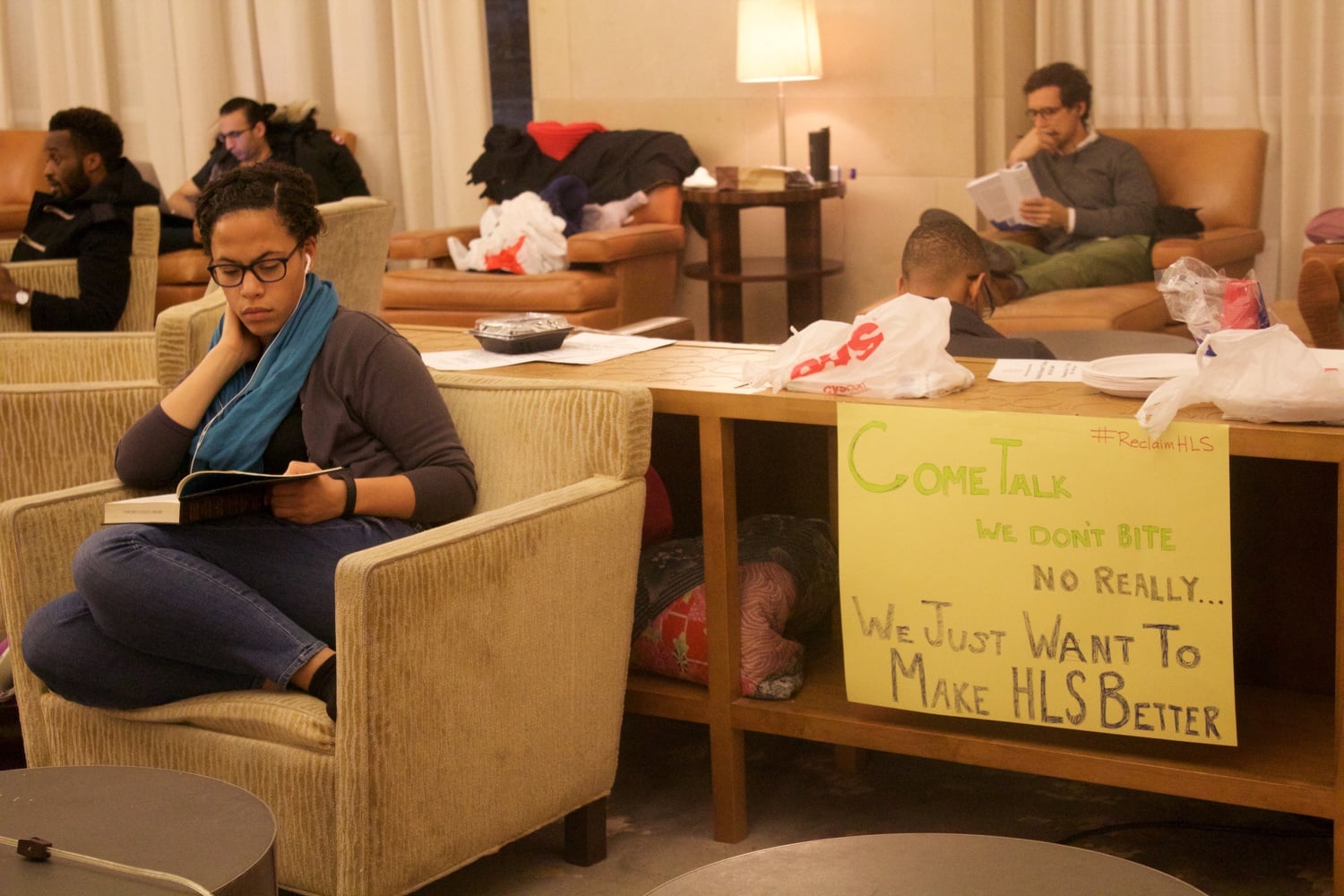 Tori Anderson, a 3L at Harvard Law School, studies by a sign in the Caspersen Student Center lounge space that student activists called 'Belinda Hall'. Students held public teach-ins and spoke to passersby about their cause over the course of their occupation.