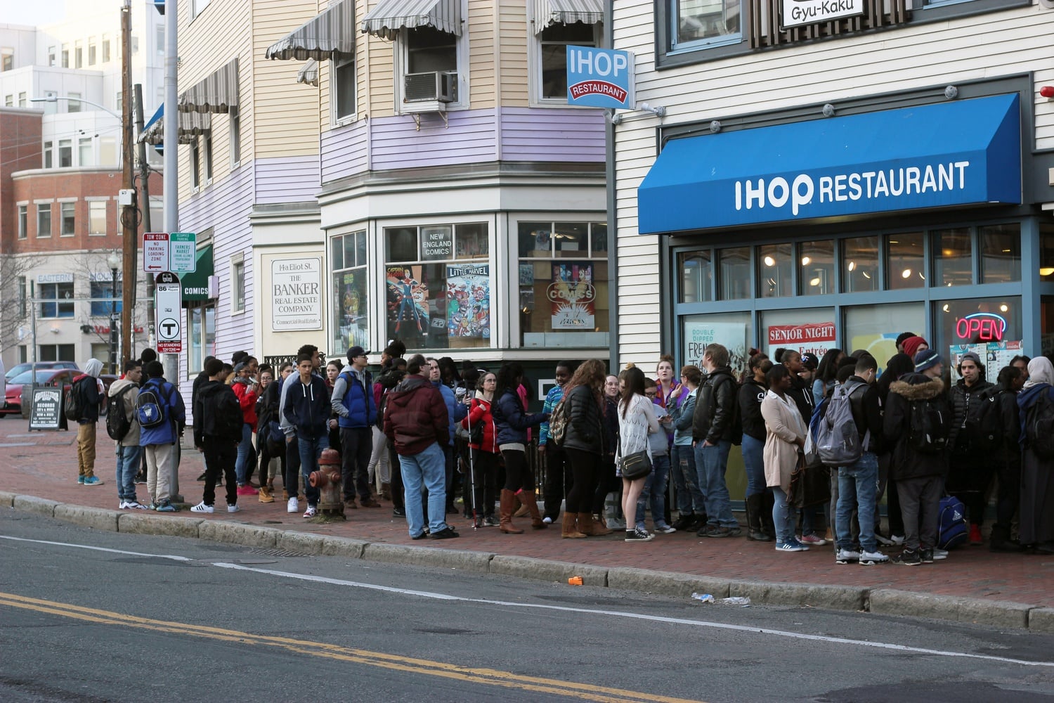 A line of customers wraps around the exterior of the Harvard Square location of IHOP on Tuesday afternoon. The Cambridge restaurant participated in IHOP’s eleventh annual National Pancake Day celebration by offering free short stacks of buttermilk pancakes.