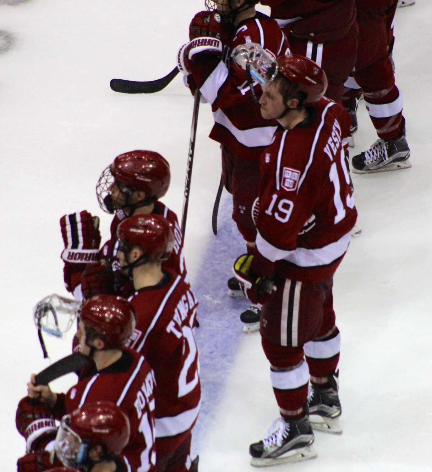 Jimmy Vesey (19) and the Crimson look on as the Whitelaw Cup is awarded to Quinnipiac.