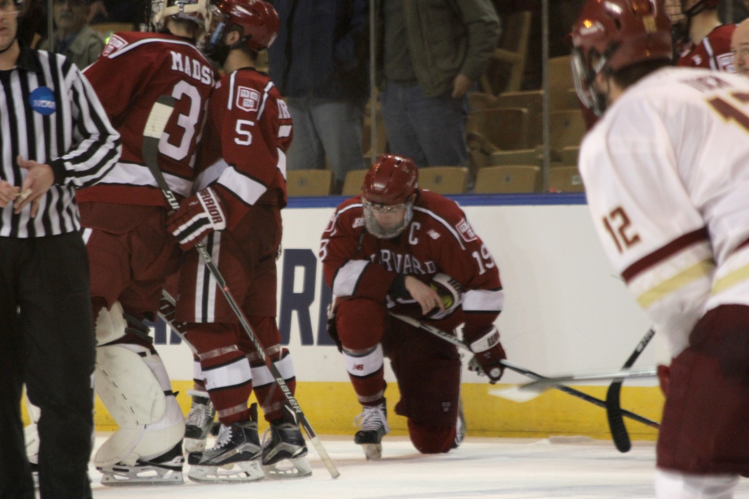Jimmy Vesey (19) gets down on one knee after the final whistle blows on both the Crimson's season and the senior's collegiate career.