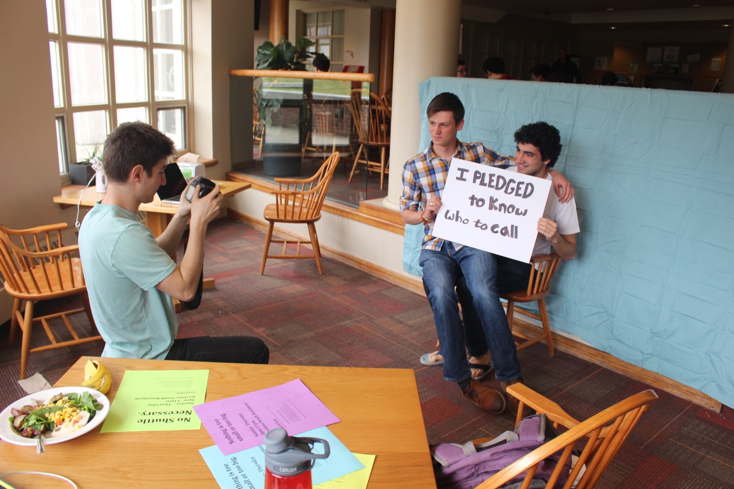 Students participate in the "Mental Health Matters" photoshoot in Cabot dining hall. The photoshoot took place in all quad dining halls on Saturday, and its purpose was to encourage students to save peer counseling groups' phone numbers into their phones.