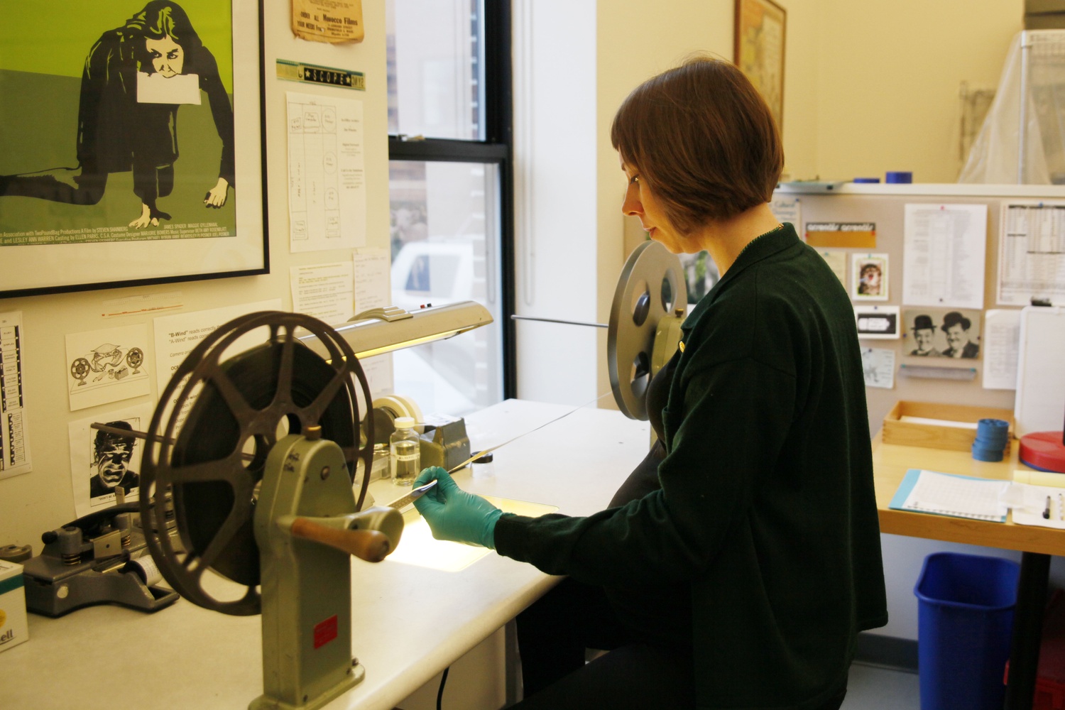 Laurel Gildersleeve, Associate Film Conservator, checks 16 mm film for tears and breaks before sending it on to the archives.  