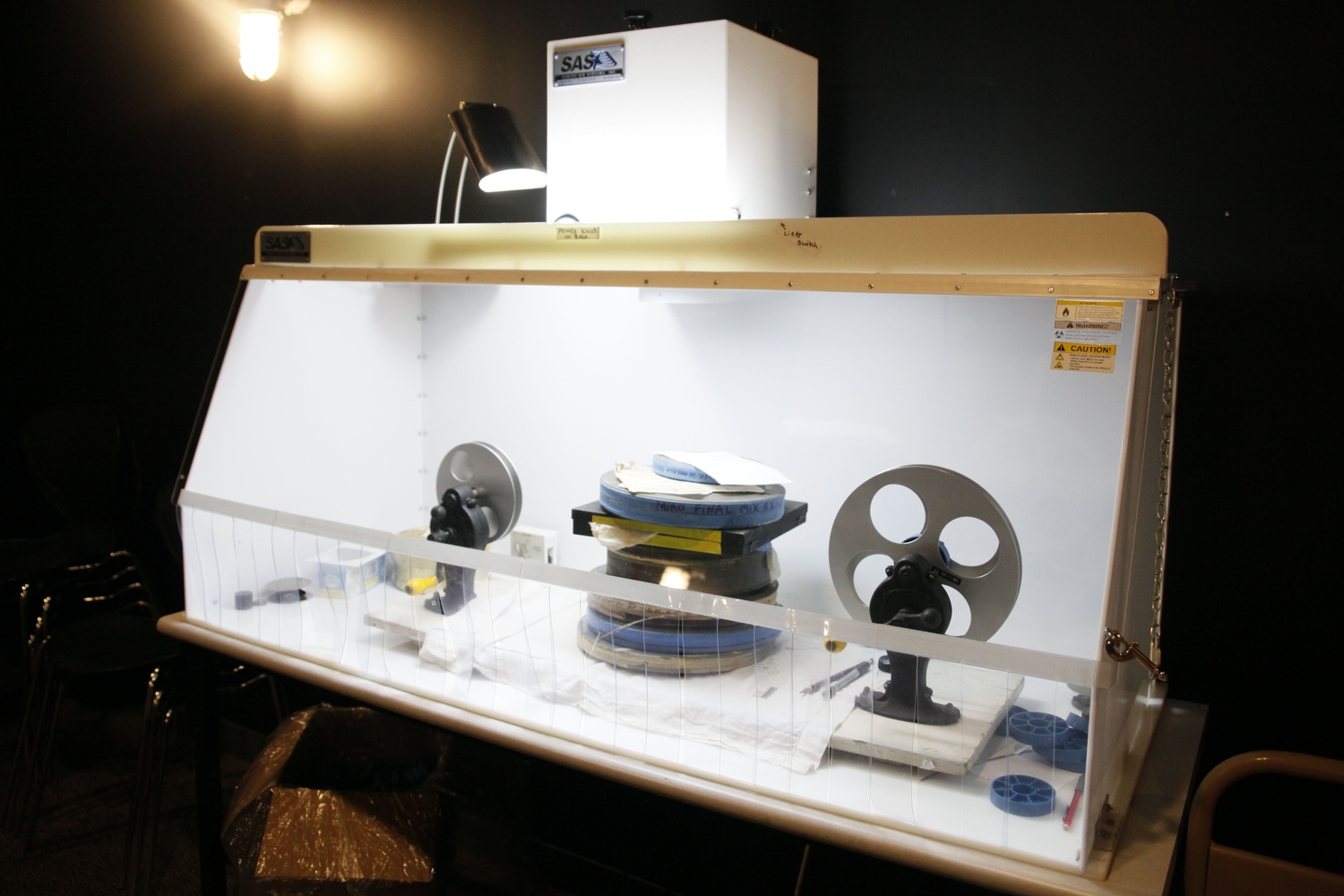 Staff inspect delicate film acquisitions in a fumigator to protect them from contact with  damaging airborne compounds.