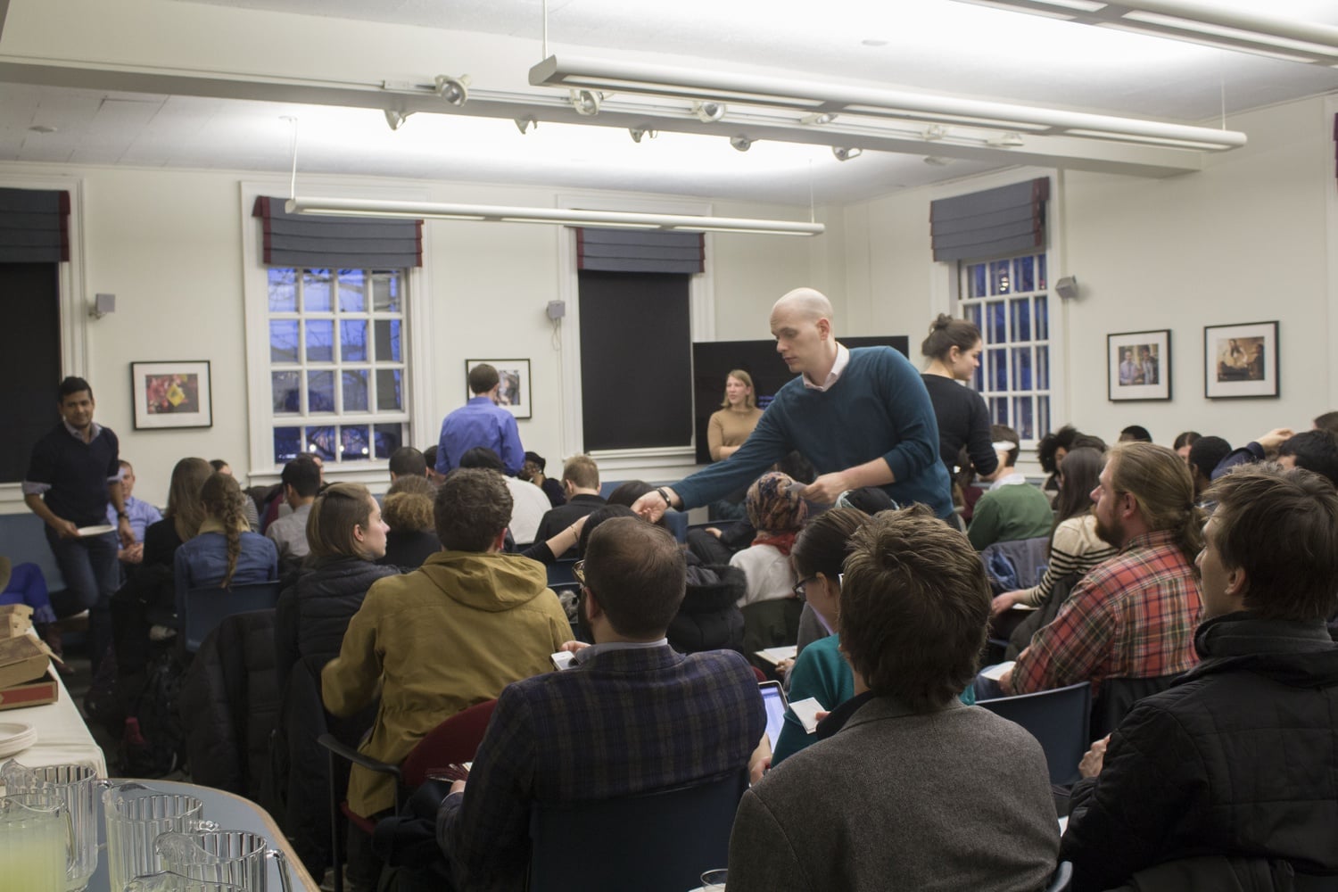 A Graduate Student Council member collects votes at a meeting Wednesday evening. In addition to voting for new leadership, the group discussed the amicus brief Harvard recently filed in opposition to graduate student unionization. 