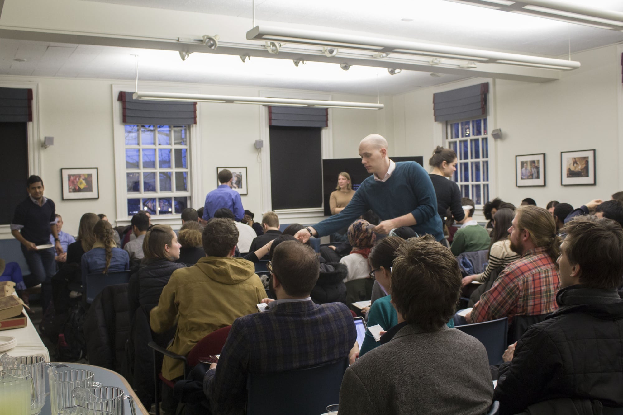 A Graduate Student Council member collects votes at a meeting Wednesday evening. In addition to voting for new leadership, the group discussed the amicus brief Harvard recently filed in opposition to graduate student unionization. 