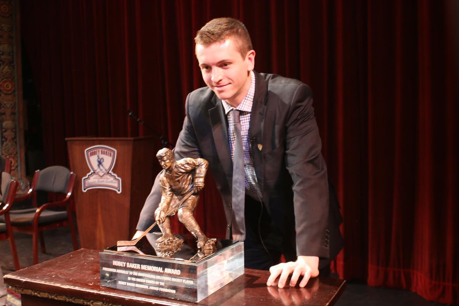 Jimmy Vesey stands behind the Hobey Baker Memorial Award on Friday after becoming the fourth Harvard player in program history to win the award.
