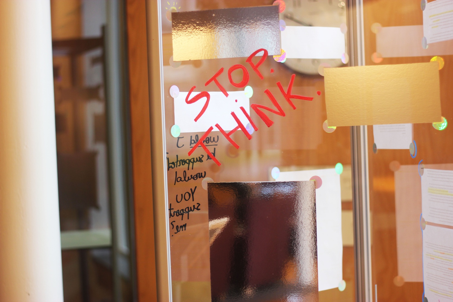 A triangular plexiglass column covered in cutouts of the University report on sexual assault stands in Ticknor Lounge on Tuesday. The column is one of 12 placed in common spaces around campus as part of an interactive art project produced by Devon M. Guinn ’17 and Delfina S. Martinez-Pandian ’17.