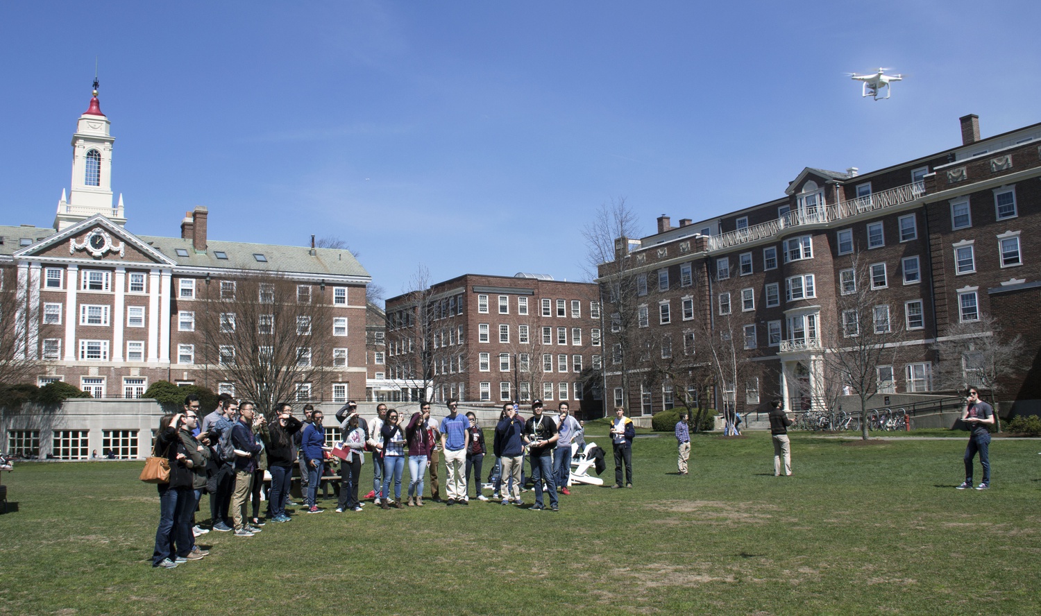 A group of students and visiting admitted students watch as a drone flies through the Quad Lawn at the Drone Fair during Visitas this weekend.