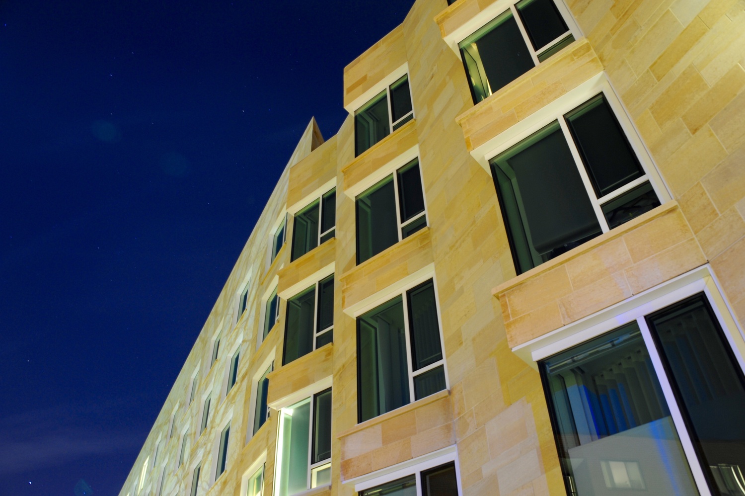 Tata Hall, a facility completed in December 2013, stands under the stars of the Allston night. The seven-story Harvard Business School building includes residential space, classrooms, and common areas for Executive Education participants.