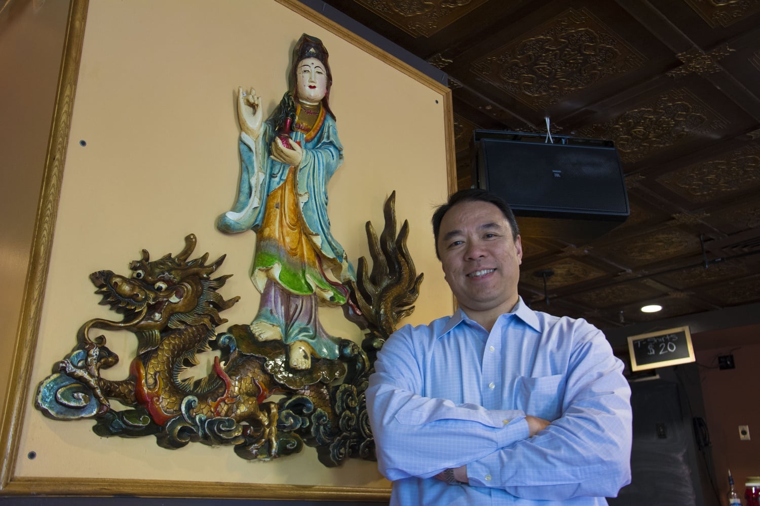 Paul Lee, owner of Hong Kong Restaurant in Harvard Square, stands next to a mural on the wall of Hong Kong's second floor. The restaurant and lounge has been a landmark in Harvard Square for over 60 years.