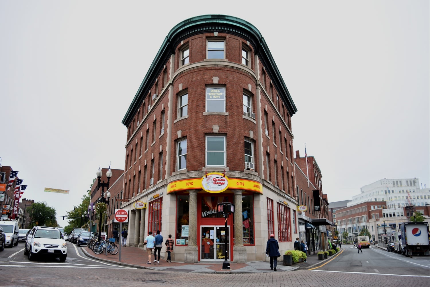 Pedestrians walk by the first Curious George store, a well-known spot in Harvard Square that is now closing down business.