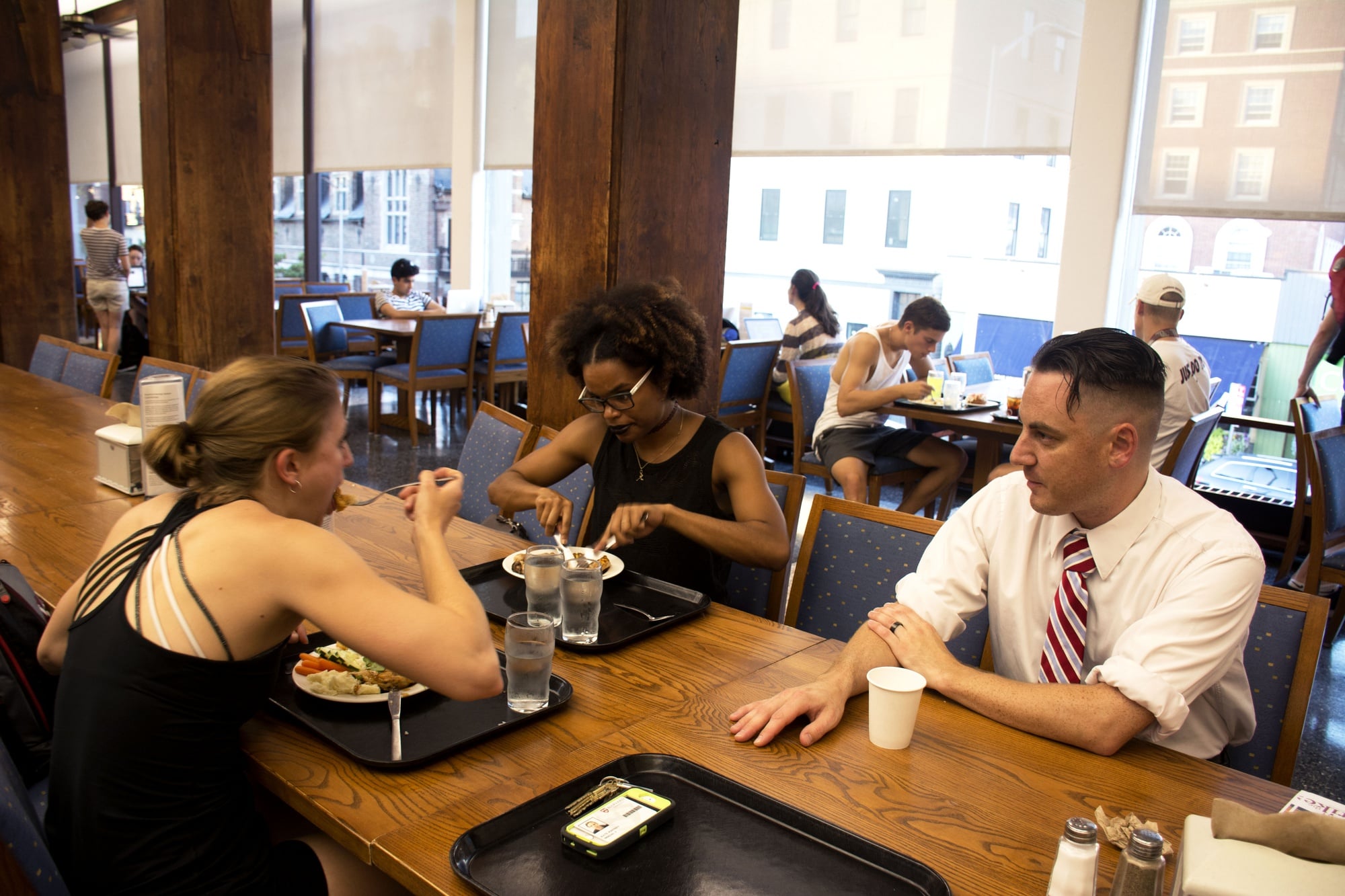 Robert A. James, a Quincy Dining Hall cook, speaks to Jacqueline D. Modesett ’17 and Jade E. Miller ’17 about the potential HUDS strike over dinner.