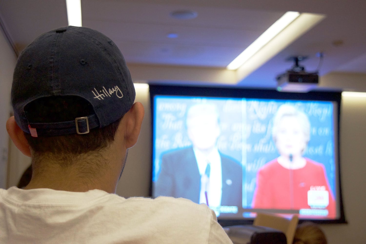 Crimson opinion editor Ruben E. Reyes, Jr. ’19 dons a Hillary Clinton cap while attending Winthrop’s presidential debate watch party in the Inn at Harvard.
