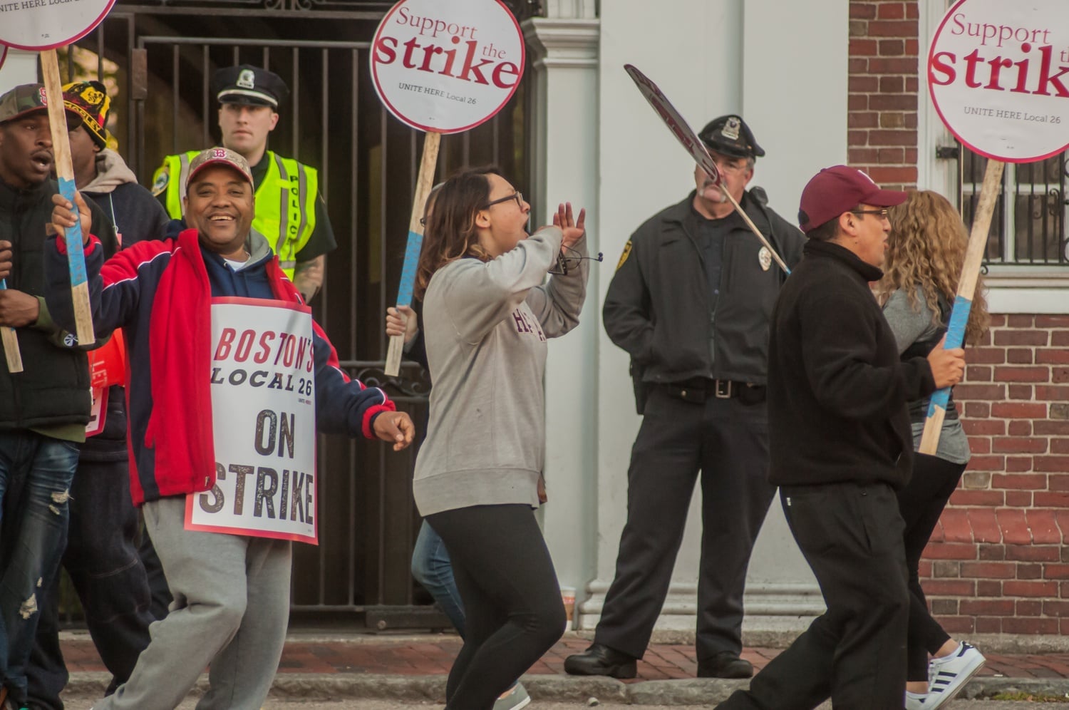 Camille E. Traslavina '18 marches with HUDS workers outside Lowell Wednesday morning. 