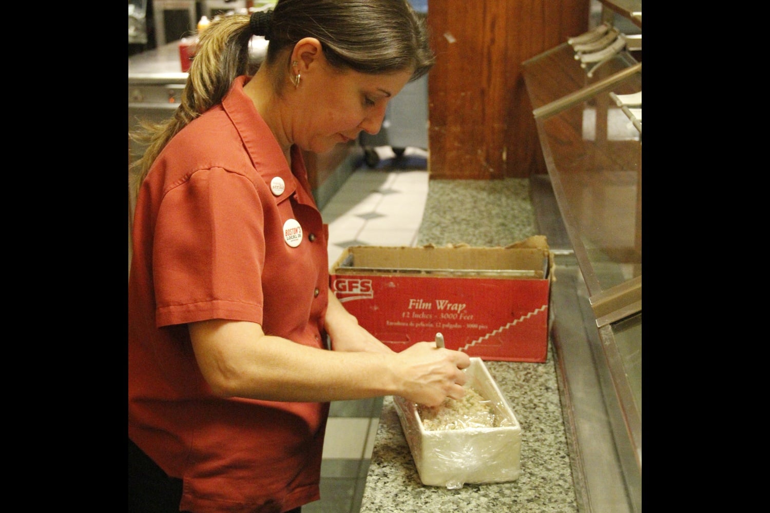 Leverett House HUDS worker Jacqueline Medeiros labels a dish for the salad bar. Jackie has been working for HUDS for 25 years.
