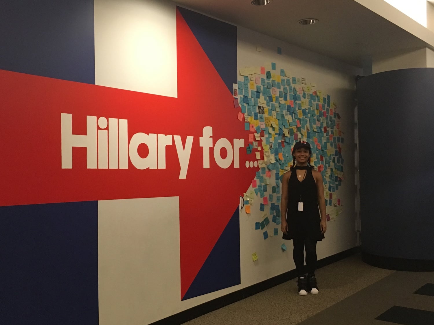 Sarafina J. Chitika '18 stands in front of a Clinton sign inside Clinton campaign headquarters.