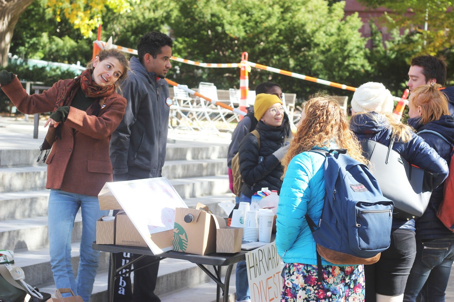 Members of Divest Harvard pass out cider and donuts and discuss fossil fuel divestment with students on the steps of Memorial Church Wednesday morning.