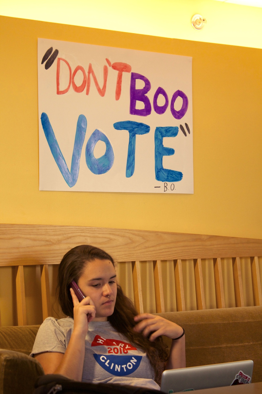 Antonia S. Washington ‘18 makes calls during a Harvard Democrats get out the vote event in Ticknor Lounge Tuesday afternoon. 
