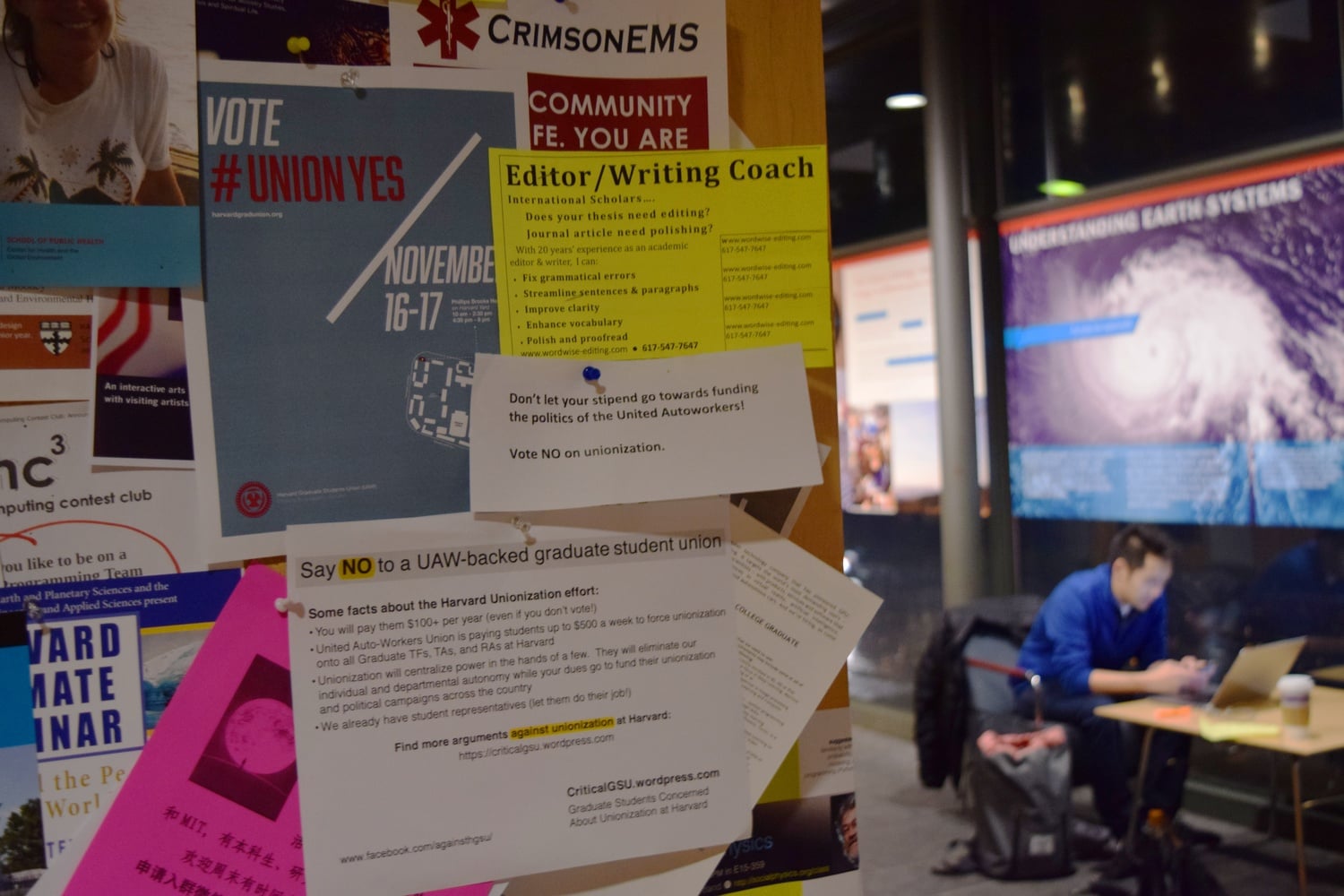 Signs supporting and opposing the graduate students establishing a union posted on the walls of the Maxwell Dworkin lobby.