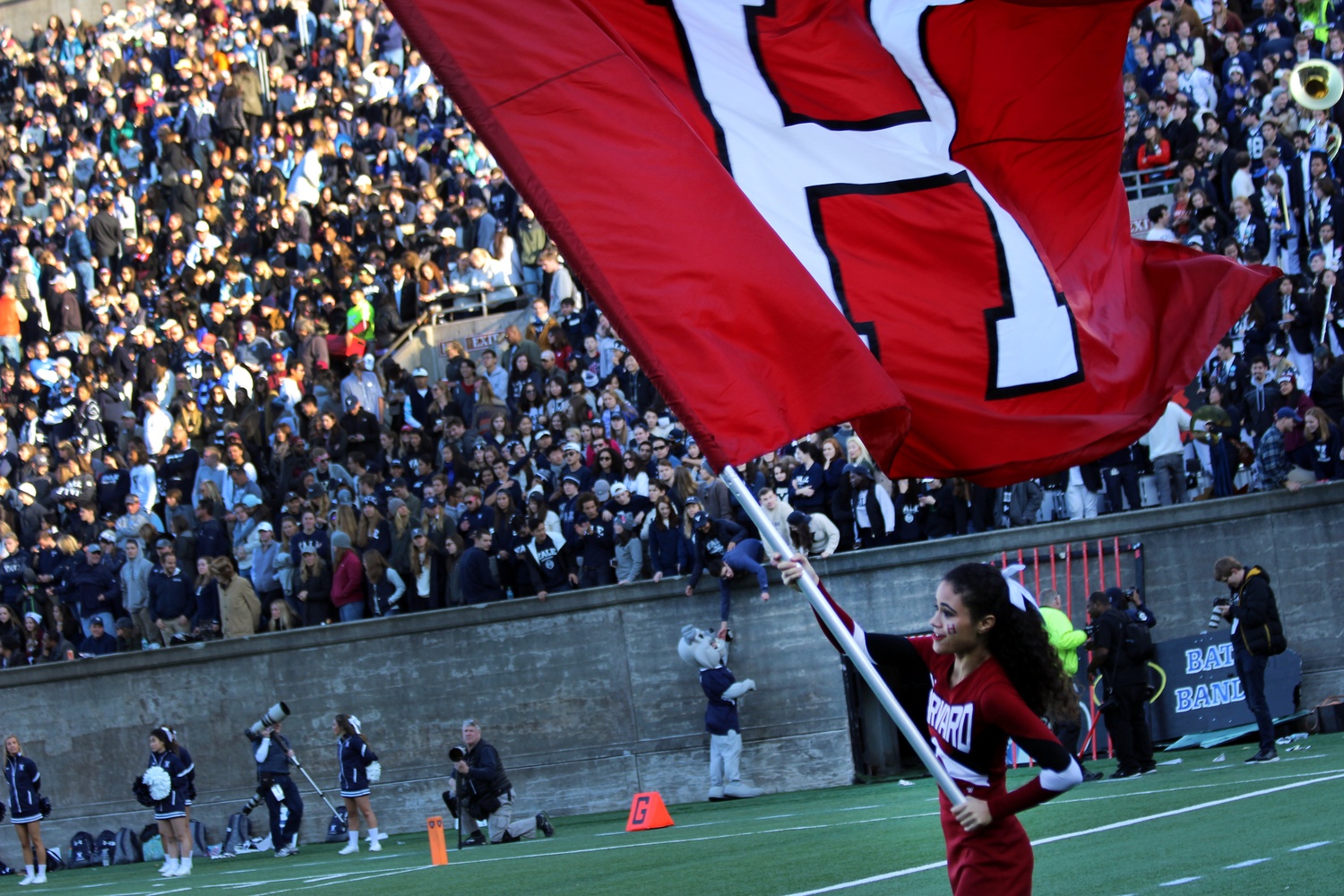 Cheerleader Camille N'Diaye-Muller '18 waves the Harvard flag during Saturday's game against Yale.