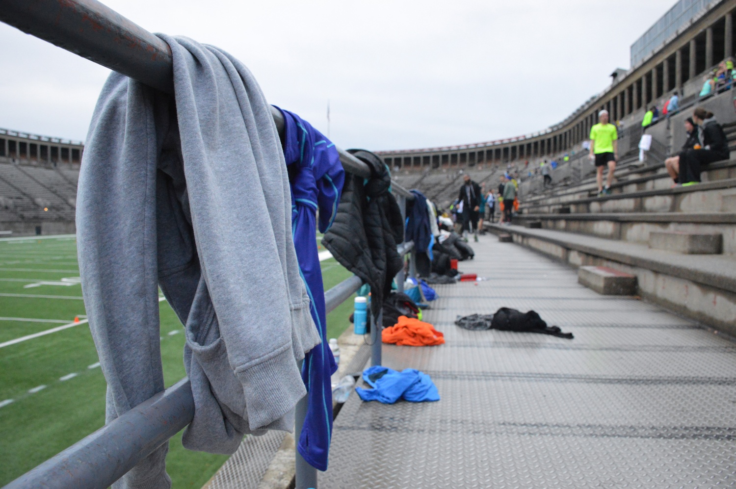 Sweaters, water bottles, and backpacks belonging to November Project participants line the railings at the foot of the stadium steps.