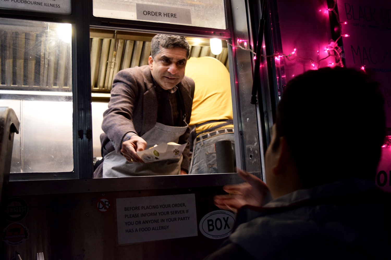 Dean of the College Rakesh Khurana hands out tacos to students Monday night outside Cabot House as a stress reliever during reading period.