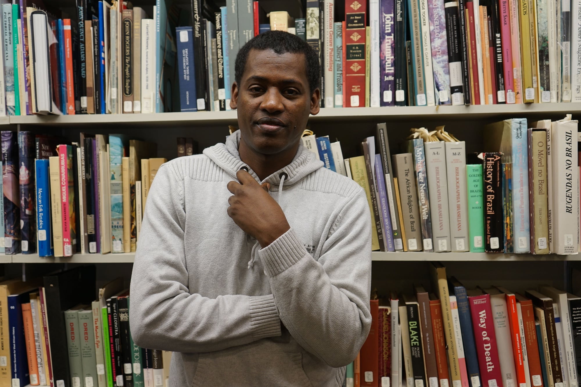 Beekan Erena in the library of The Hutchins Center for African & African American Research, which hosted him as a Scholars at Risk Fellow last year. 