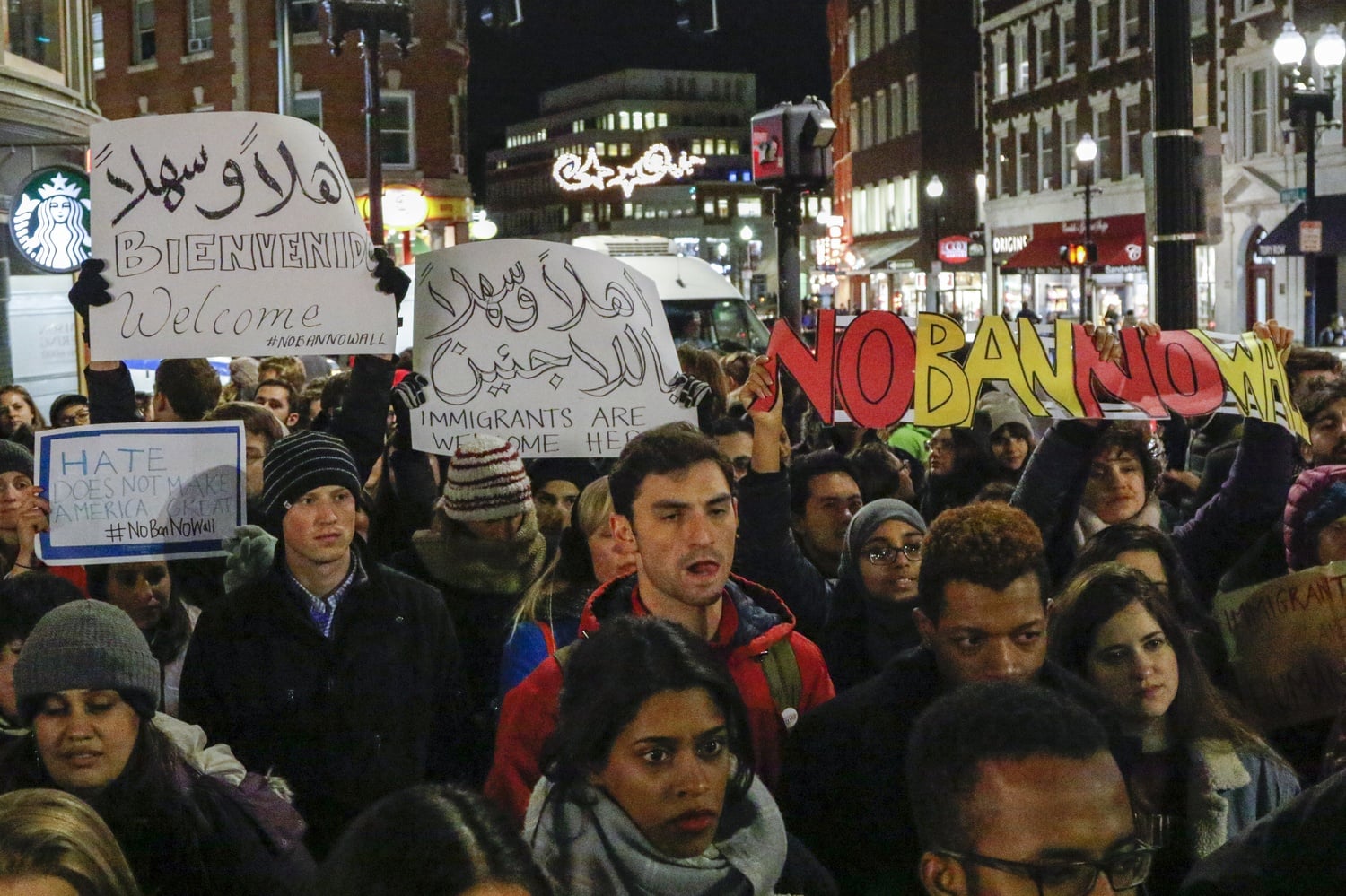 Demonstrators hold signs opposing President Donald Trump's immigration ban during a rally in Harvard Square in January.
