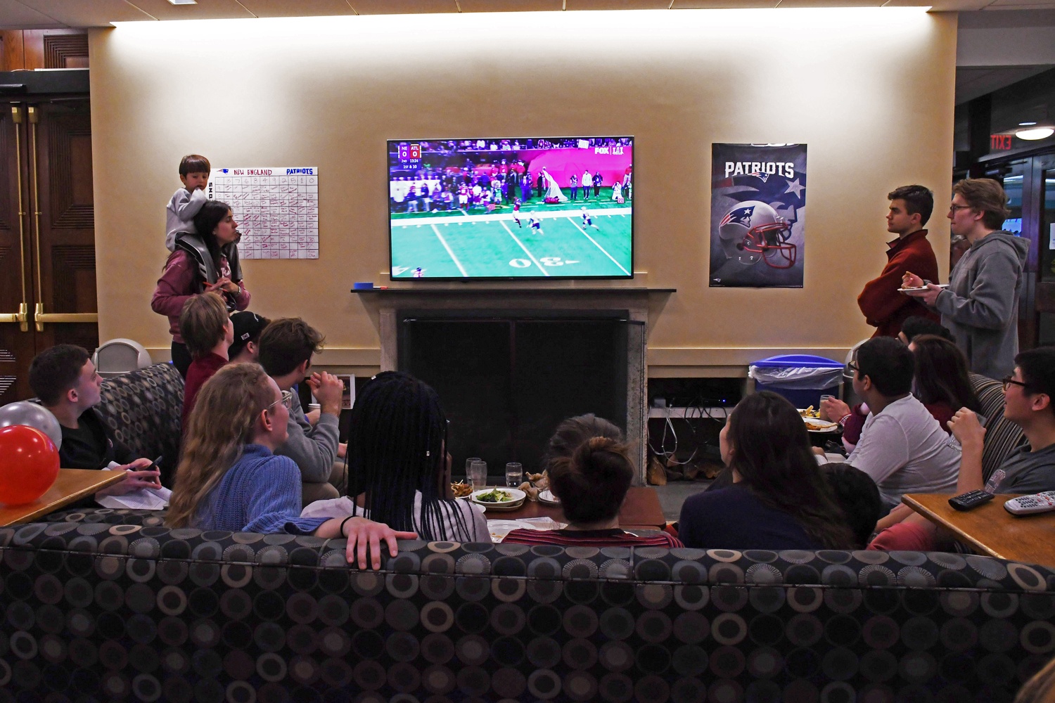 Students watch the New England Patriots face the Atlanta Falcons at a Super Bowl watch party in Quincy House on Sunday evening.