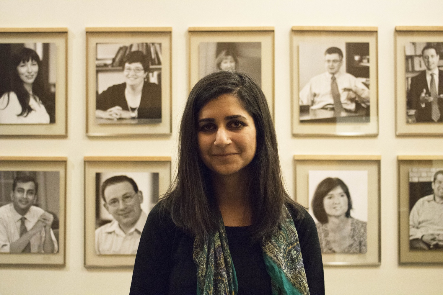 Niku Jafarnia stands in front of pictures of former Harvard Law School professors.