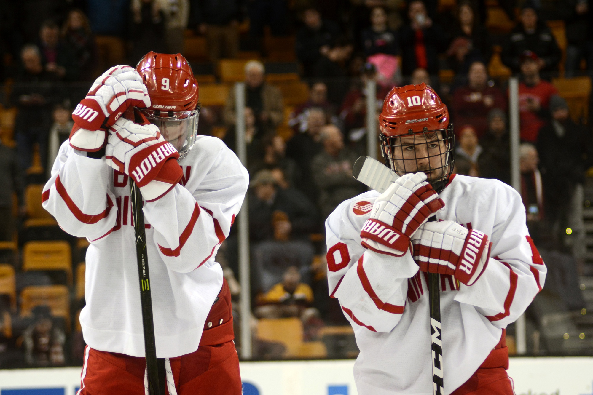 Defeated Boston University hockey forwards Kieffer Bellows and Gabriel Chabot watch the Beanpot trophy ceremony following Monday's final match against Harvard. Harvard bested the Terriers, 6-3.