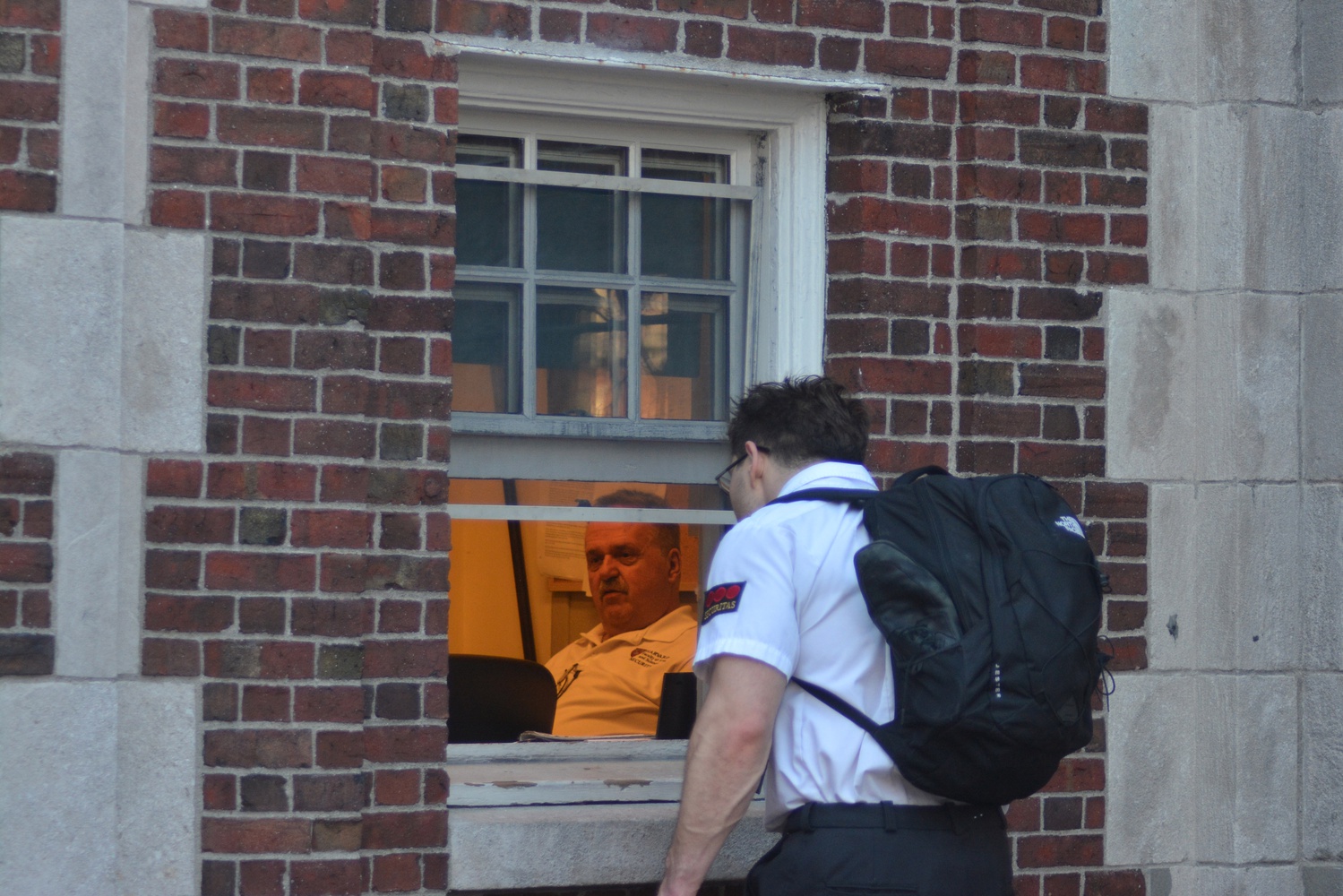 A Securitas guard checks in near Widener Gate. Harvard maintains security stations at various locations throughout campus.