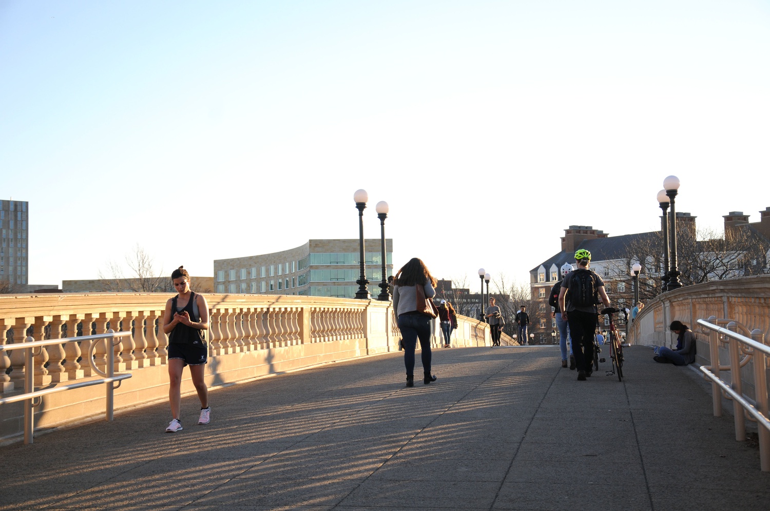 Pedestrians cross the John W. Weeks Bridge as the sun sets Thursday evening.