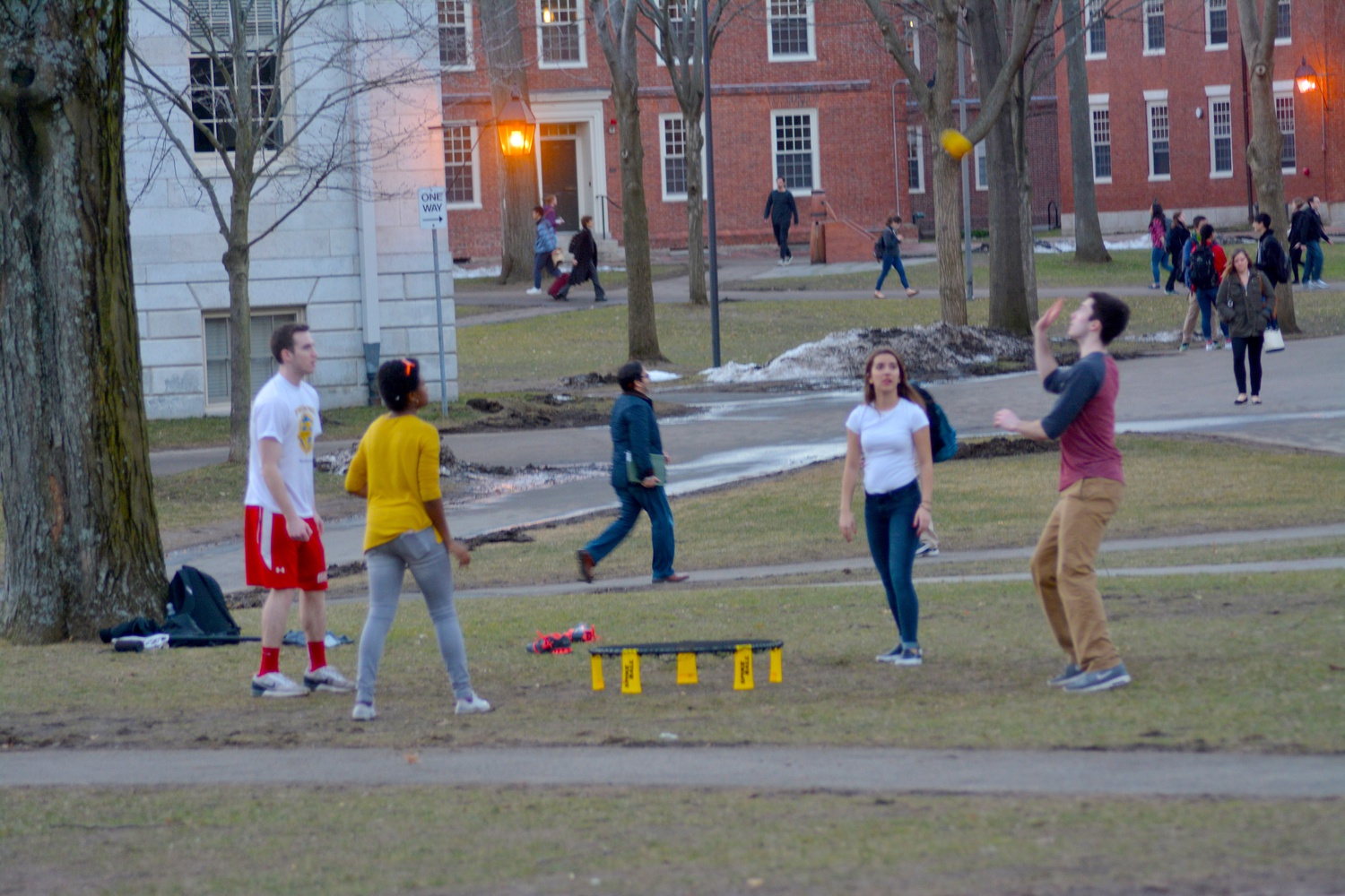 Students enjoy the unusually warm weather with a game of Spikeball in Harvard Yard Thursday afternoon.
