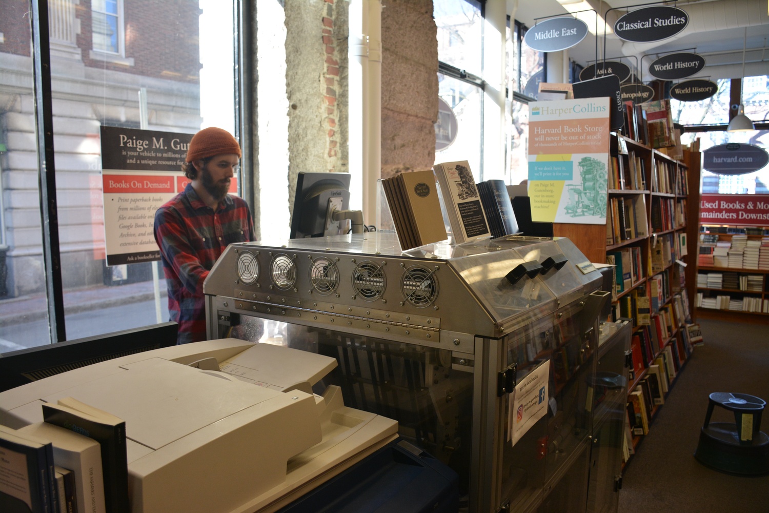 Spencer M. Hawkes, a young, bearded, beanie-clad man, oversees the book machine’s operation as the print-on-demand manager.