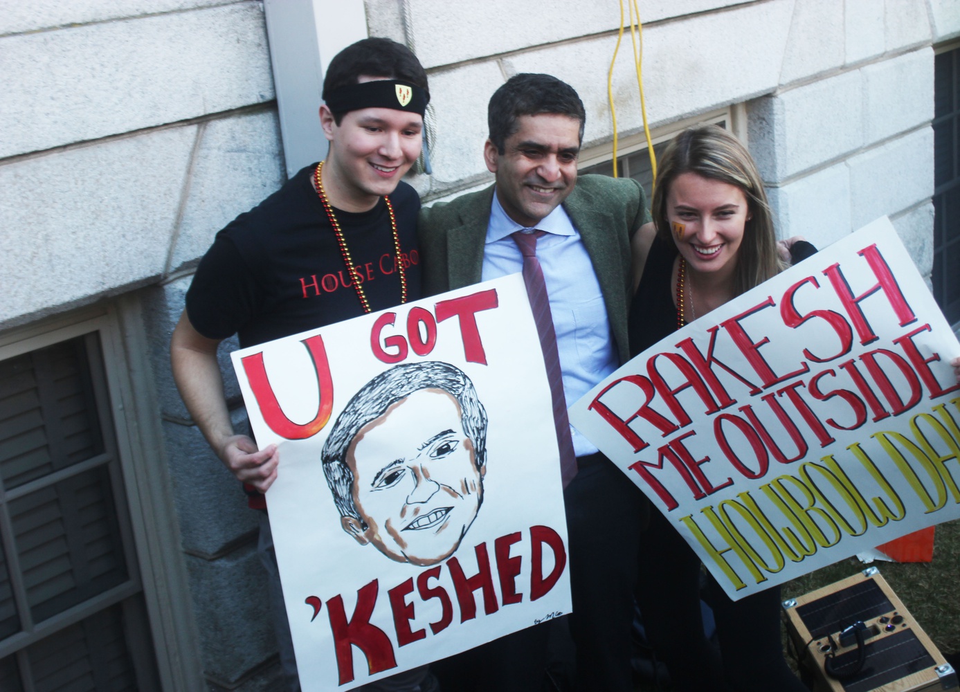 Members of Cabot House pose for a photo with Dean of the College and Cabot Faculty Dean Rakesh Khurana with posters depicting popular memes involving Khurana.