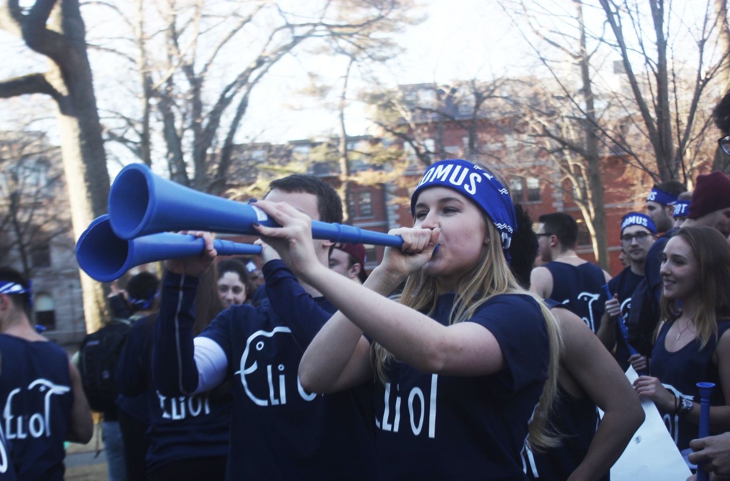 Members of Eliot House use noisemakers in the yard on Housing Day.